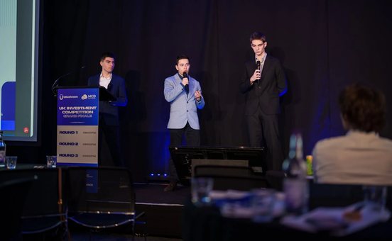 Finalists presenting on stage at a UMushroom investment competition final